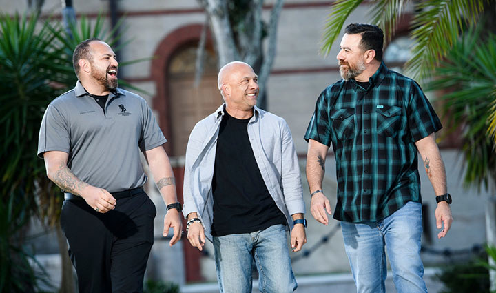 Warriors Joe Stabley, Benjamin Heck and another warrior are sharing a laugh walking from a building together.