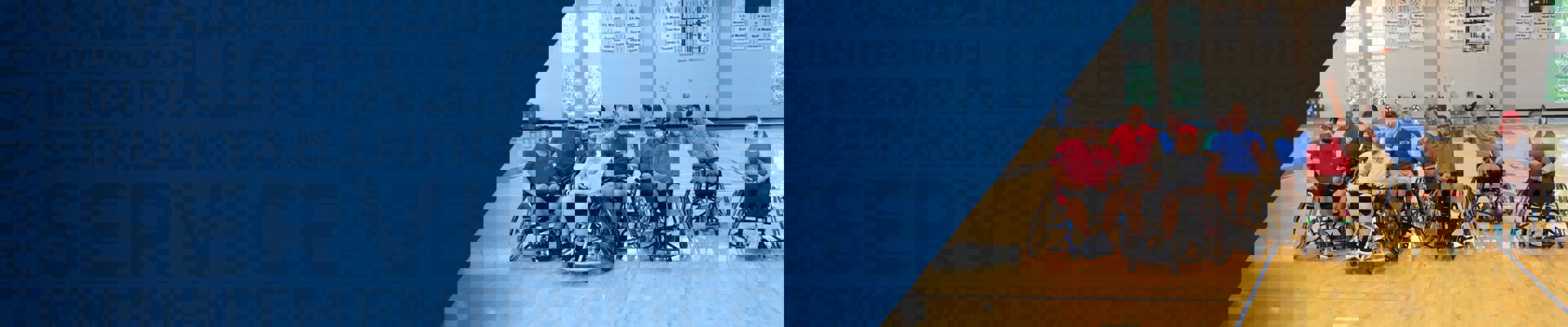 A group of wounded warriors pose for a photo during an adaptive basketball event.