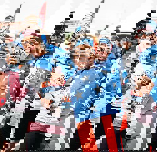 Cheerful race participants posing for a group picture during WWP’s Carry Forward 5K.