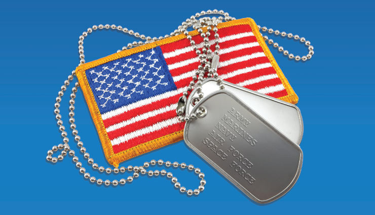 A pair of military dog tags resting on a U.S. flag patch with a yellow border, set against a blue background. The tags list military branches: Army, Marines, Navy, Air Force, and Space Force.