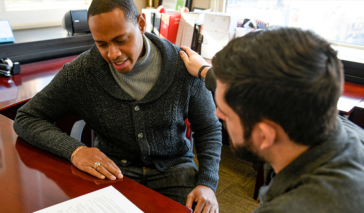 Wounded warrior Tyshawn Jenkins sitting at a desk filling out paperwork with an advisor.