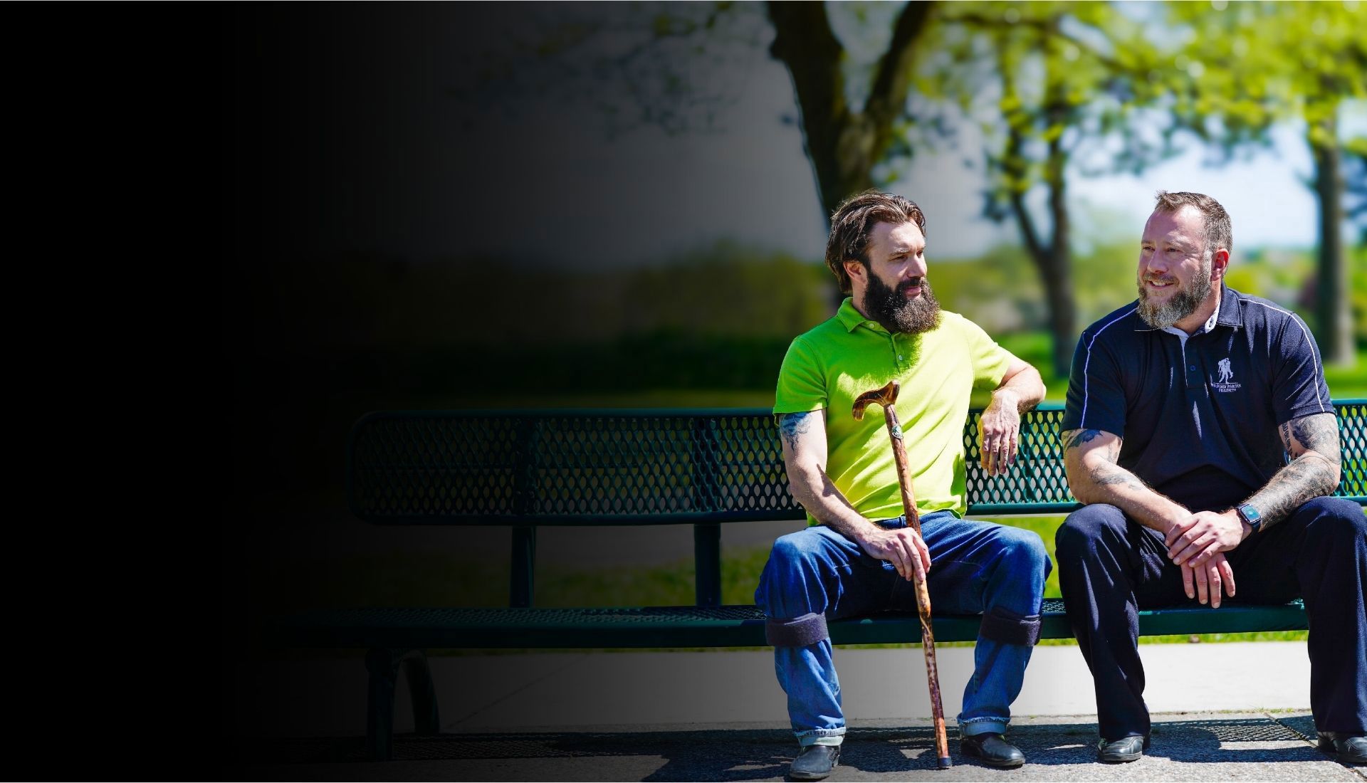 Warriors Andrew Carpenter and Anthony Craiden sit outside on a bench together talking with each other.