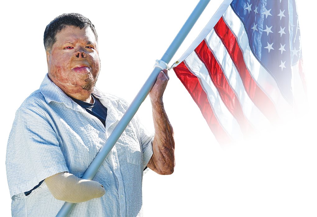 Wounded Warrior Anthony Villareal, a veteran, holds an American flag on a pole.
