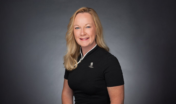 Jennifer Jenkins poses for a headshot in a black WWP polo shirt.
