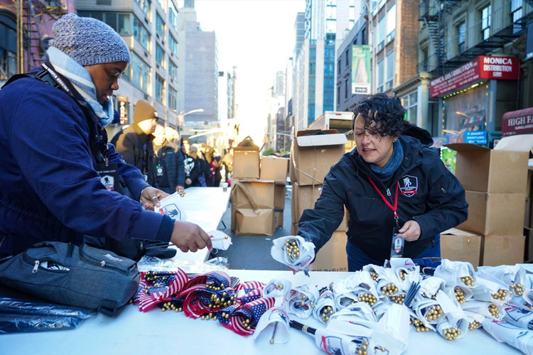 WWP teammate and volunteer lay out flags on table during the Veterans Day parade in New York City.