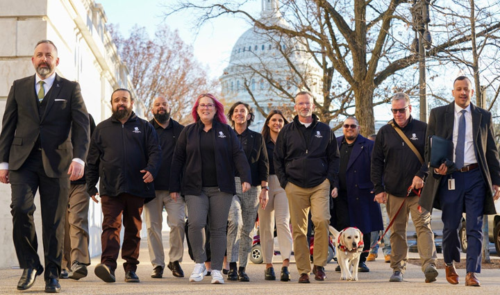 A group of WWP warriors walks toward the camera with the US Capitol building in the background. 